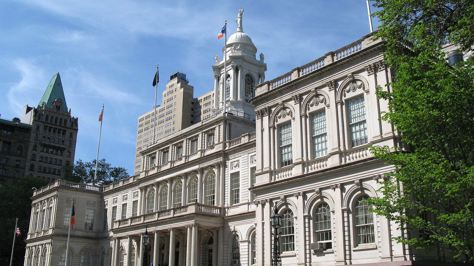 Fachada del Ayuntamiento de Nueva York detrás de árboles en City Hall Park